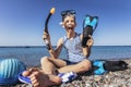 Boy has water polo ball and scuba gear on the beach. Looking at camera. Concept of travel, tourism, family Royalty Free Stock Photo