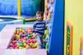 Happy boy having fun in ball pit in kids amusement park and indoor play center. Child playing with colorful balls in playground Royalty Free Stock Photo