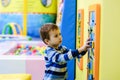 Happy boy having fun in ball pit in kids amusement park and indoor play center. Child playing with colorful balls in playground Royalty Free Stock Photo