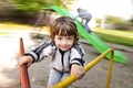 Happy boy having fun on carousel playground outdoors Royalty Free Stock Photo