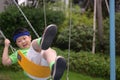 A boy with a headband have a ride on a swing Royalty Free Stock Photo