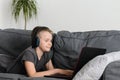 Happy boy in headphones playing or studying on laptop computer at home. Child use pc Royalty Free Stock Photo