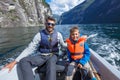 Happy boy with his father driving the motorboat, Norway. They are enjoying the moment. Royalty Free Stock Photo