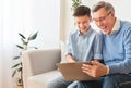 Happy Boy And His Grandfather Using Laptop Sitting On Sofa Royalty Free Stock Photo