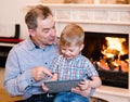 Happy boy and his grandfather using a tablet computer Royalty Free Stock Photo