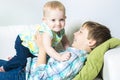 Happy boy holding his sister baby on sofa Royalty Free Stock Photo