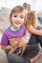 Happy boy holding kitten while sitting with family Royalty Free Stock Photo