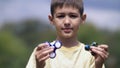 Happy Boy holding play two fidget spinners on nature