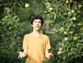 Happy boy juggling apples smile wink on apple tree green garden background