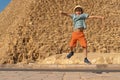 Happy boy jumping in front of the Cheops pyramid on the Giza plateau Royalty Free Stock Photo