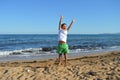 Happy boy jumps on the beach by the sea Royalty Free Stock Photo