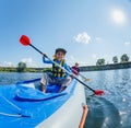 Happy boy kayaking on the river on a sunny day during summer vacation Royalty Free Stock Photo