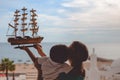 Happy boy kissing mother and holding ship model on Royalty Free Stock Photo