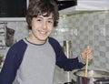 Happy Boy is in kitchen on a stove cooking soup Royalty Free Stock Photo