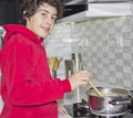 Happy Boy is in kitchen on a stove cooking soup Royalty Free Stock Photo