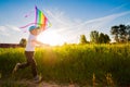 Happy boy with a kite running in a meadow in summer in nature. Royalty Free Stock Photo