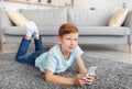 Happy boy laying on floor, using mobile phone Royalty Free Stock Photo