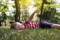 A happy boy lies in the grass, stroking her and looking at the sky. Sometimes something says or points a finger to the top. The Royalty Free Stock Photo