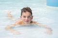 A happy boy lies in the water park in the pool Royalty Free Stock Photo