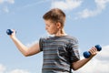 Happy boy lifting dumbbells Royalty Free Stock Photo