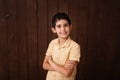 Happy boy in light yellow t-shirt. Isolated over brown background. Schoolboy. Teenager.