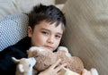 Happy boy lying on sofa looking up at camera with smiling face,Positive Child resting in living room with bright light shining Royalty Free Stock Photo