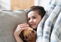 Happy boy lying on sofa relaxing watching TV in morning on early autumn, Comfortable Child laying down on couch with blanket and Royalty Free Stock Photo