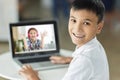 Happy boy meet his classmate online with laptop