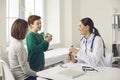 Happy boy patient explaining something during checkup visit to woman pediatrician