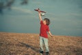 Happy boy play in airplane outdoors. Concept of dreams and travels. Dreams of flying planes. Kids having fun with toy Royalty Free Stock Photo