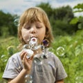 Happy Boy play in bubbles in field sunny summer day Royalty Free Stock Photo
