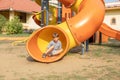 Happy Boy On Playground Rides Bright Orange Tube Slide On Summer Day. Fun Pastime.