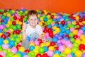 Happy boy playing in ball pit on birthday party in kids amusement park and indoor play center. Child playing with Royalty Free Stock Photo