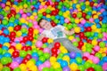 Happy boy playing in ball pit on birthday party in kids amusement park and indoor play center. Child playing with Royalty Free Stock Photo