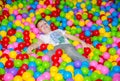 Happy boy playing in ball pit on birthday party in kids amusement park and indoor play center. Child playing with Royalty Free Stock Photo