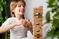 happy boy playing board game, building a tower of wooden cubes, jenga logic game for child development Royalty Free Stock Photo