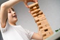 happy boy playing board game, building a tower of wooden cubes, jenga logic game for child development Royalty Free Stock Photo