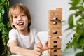 happy boy playing board game, building a tower of wooden cubes, jenga logic game for child development Royalty Free Stock Photo