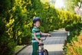 Happy boy playing with a bunch of balloons outside and riding a scooter. Back view Royalty Free Stock Photo