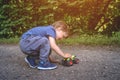 Happy boy playing with a car remote. Small child playing in the Park with a toy car. Kid with toy tractor playing on the