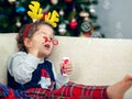 Happy boy playing with a Christmas tree in the background Royalty Free Stock Photo