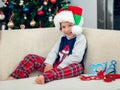 Happy boy playing with a Christmas tree in the background Royalty Free Stock Photo