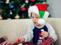 Happy boy playing with a Christmas tree in the background Royalty Free Stock Photo