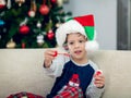 Happy boy playing with a Christmas tree in the background Royalty Free Stock Photo