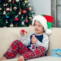 Happy boy playing with a Christmas tree in the background Royalty Free Stock Photo