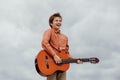 Happy boy playing guitar, dressed in a shirt, Royalty Free Stock Photo