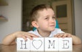 Happy boy plays with cubes and puts it together in word Royalty Free Stock Photo