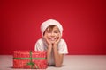 happy boy posing in Santa Claus hat on red studio background. Christmas concept Royalty Free Stock Photo