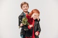 happy boy presenting roses bouquet to his little girlfriend