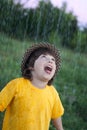 Happy boy in rain summer outdoors